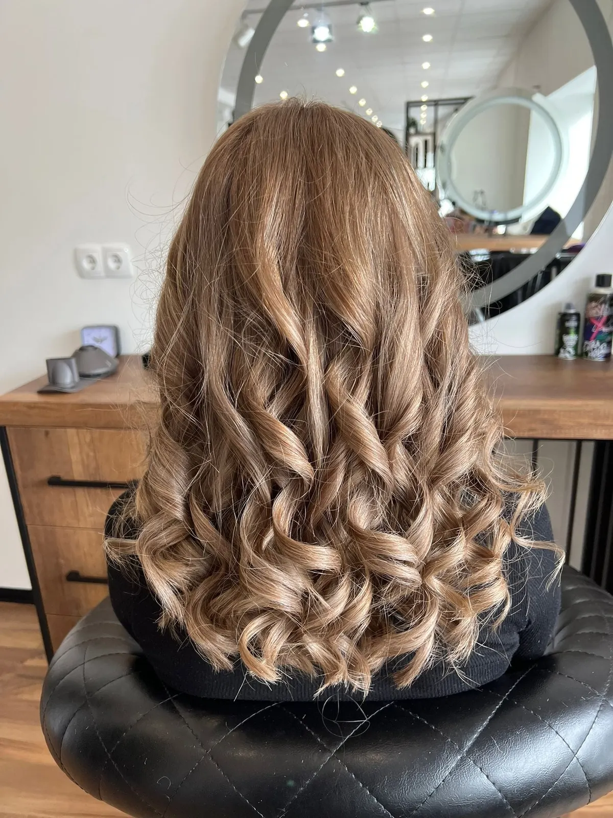 Kundin mit hellbraunen, voluminösen Locken im Salon Mr & Mrs